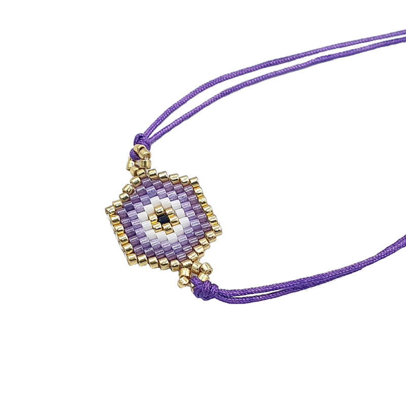 Beaded purple and gold eye pendant on a purple cord necklace, close-up.