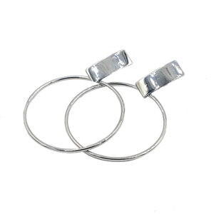Pair of shiny silver hoop earrings with rectangular top clasps, overlapping slightly.