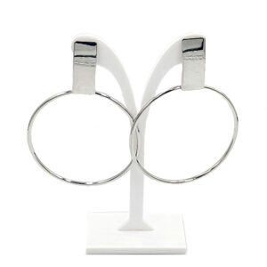 Pair of large silver hoop earrings displayed on a white stand.