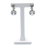 Pair of silver drop earrings with round clear stones on a white display stand, jewelry product photo