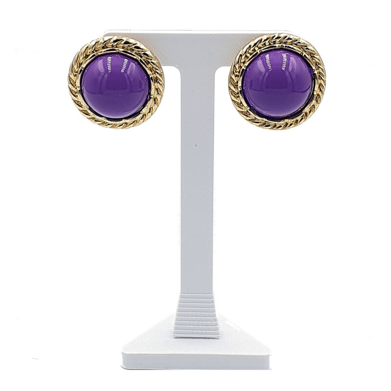 Purple cabochon stud earrings with gold twisted rope border on a white display stand