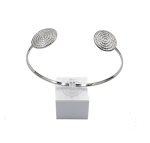 Silver-toned open cuff bracelet with two textured circular ends, displayed on a small white pedestal.
