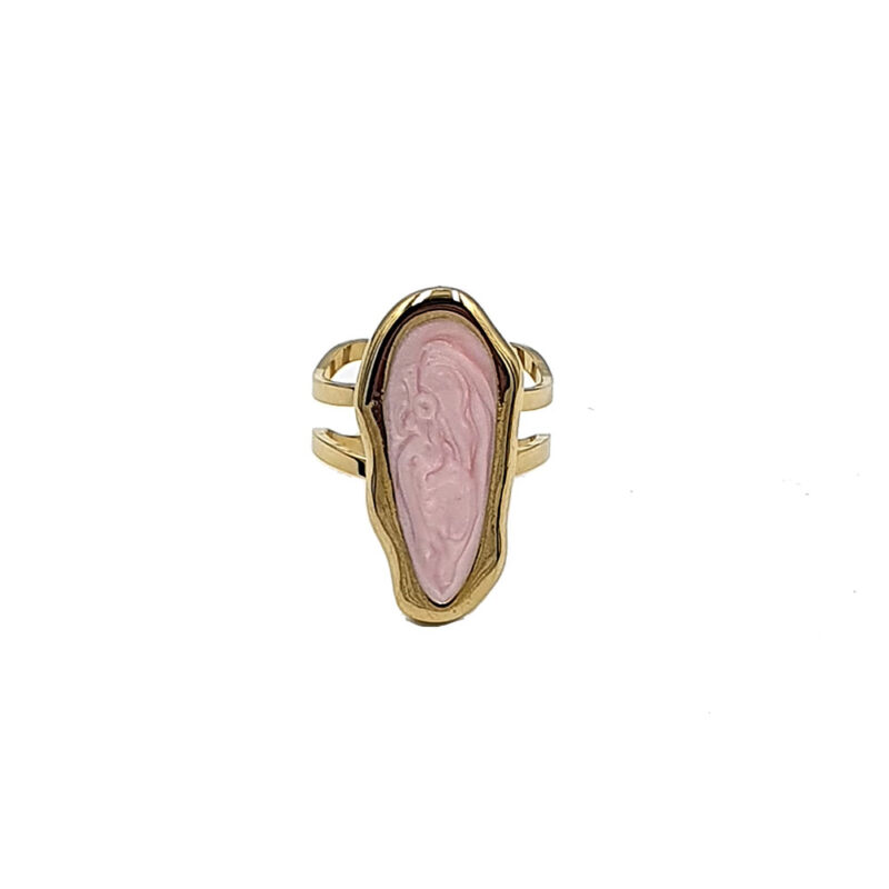 Gold-tone ring with an elongated pink carved cameo set in a bezel on a split-band design; features a raised relief figure.