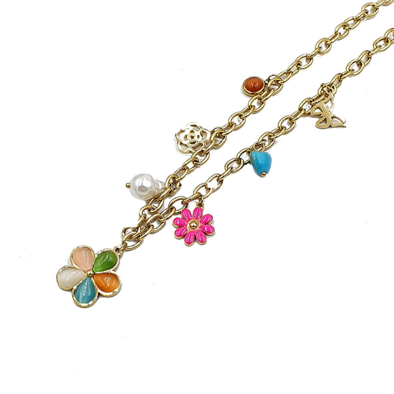 Gold-tone layered necklace with multiple charms: a multicolor petal flower pendant, pink flower, pearl bead, turquoise heart, and small decorative charms.