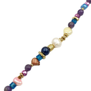 Colorful beaded necklace with purple, pink, blue beads and gold accents, laid diagonally across a white background