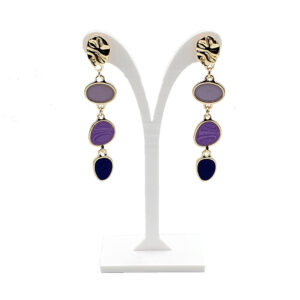 Gold-tone drop earrings with four colored stones (lavender to navy) on a white display stand.