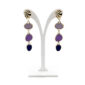 Gold-tone drop earrings with four colored stones (lavender to navy) on a white display stand.