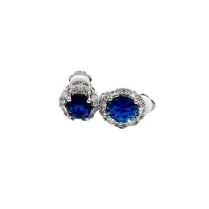 Pair of round blue gemstone stud earrings with diamond halos on a silver setting.