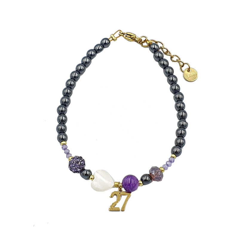 Beaded bracelet with a gold '27' charm, white heart bead, purple and lilac beads, and dark gray seed beads.
