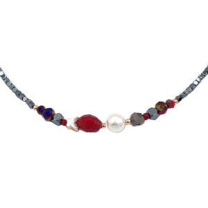 Beaded necklace with a large red faceted bead, a white pearl centerpiece, and gray faceted beads on a delicate chain.