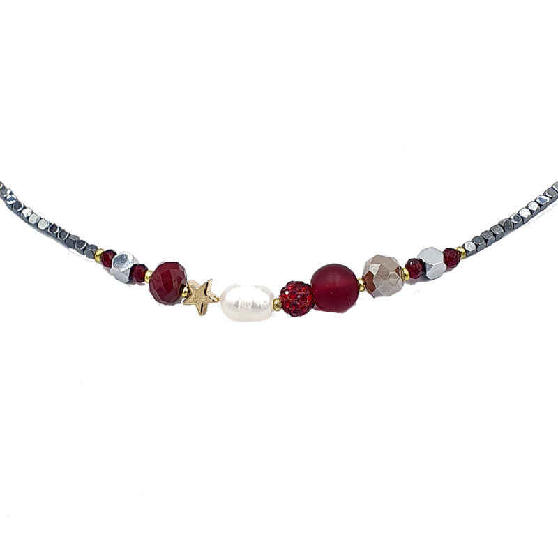 Beaded necklace with red, silver, and white beads and a small gold star charm on a thin cord mix of shapes.