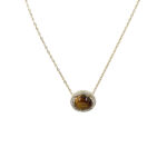 Gold chain necklace with oval tiger's eye gemstone surrounded by small diamonds on a halo pendant lens.