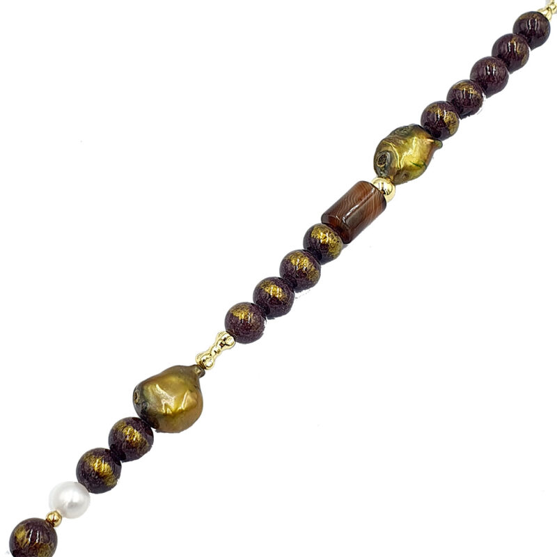Beaded necklace with dark brown and gold-toned round beads, a large gold focal bead, and a single white pearl accent.