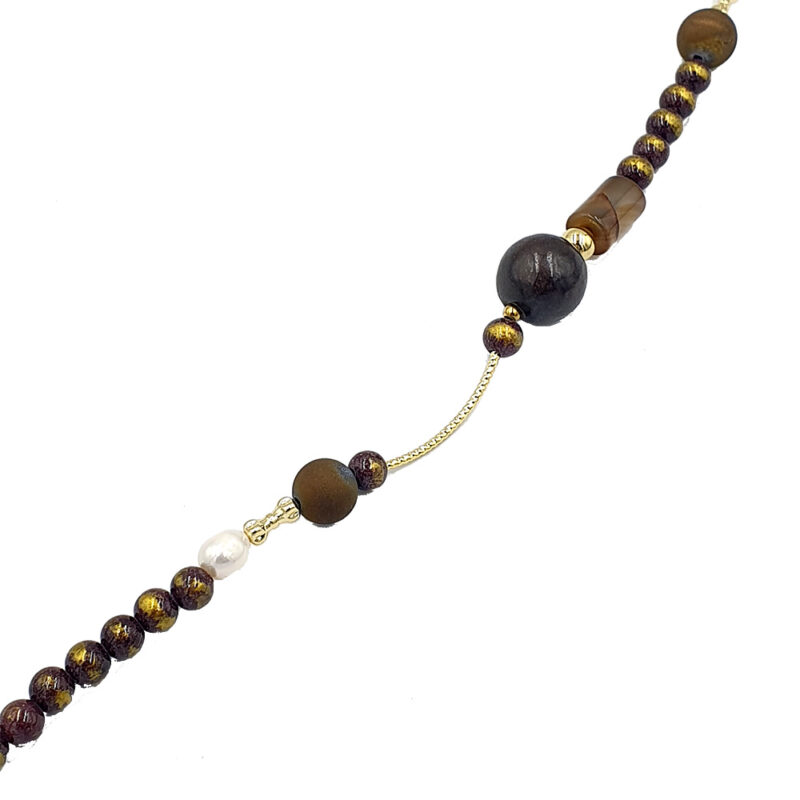 Beaded necklace with dark purple and gold marbled beads, a white pearl accent, and a small gold chain detail.
