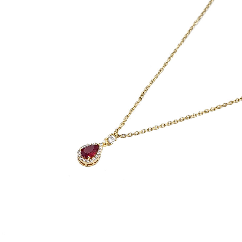 Κολιέ με κόκκινη πέτρα 2 - bijouxbijoux Gold necklace with a teardrop red gemstone pendant surrounded by small white stones on a white background.