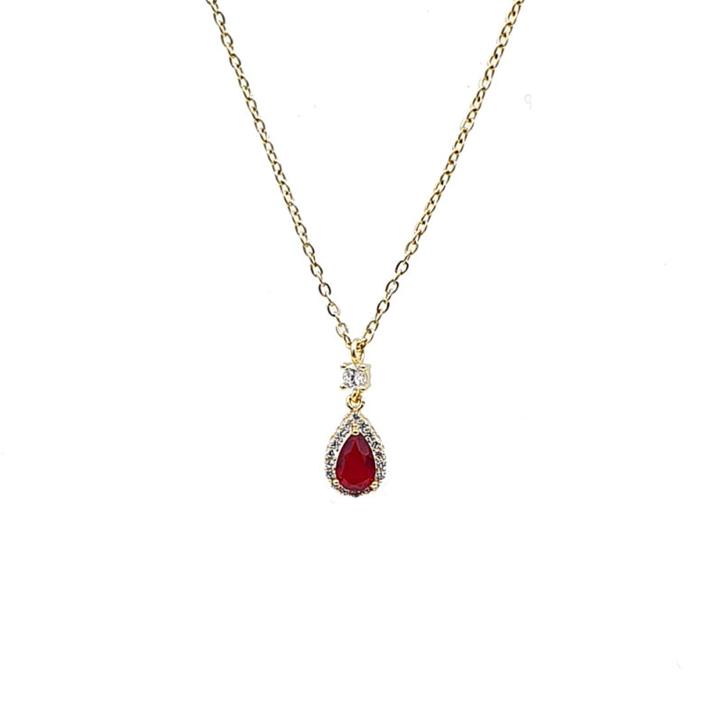 Κολιέ με κόκκινη πέτρα - bijouxbijoux Gold chain necklace with a teardrop red gemstone pendant surrounded by small clear stones and a tiny diamond above, on a white background.
