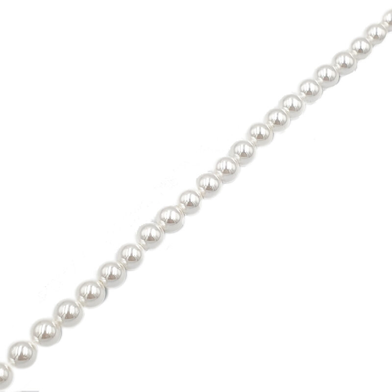 Diagonal strand of shiny silver beads (pearl-like) on a white background, a close-up of a jewelry necklace component